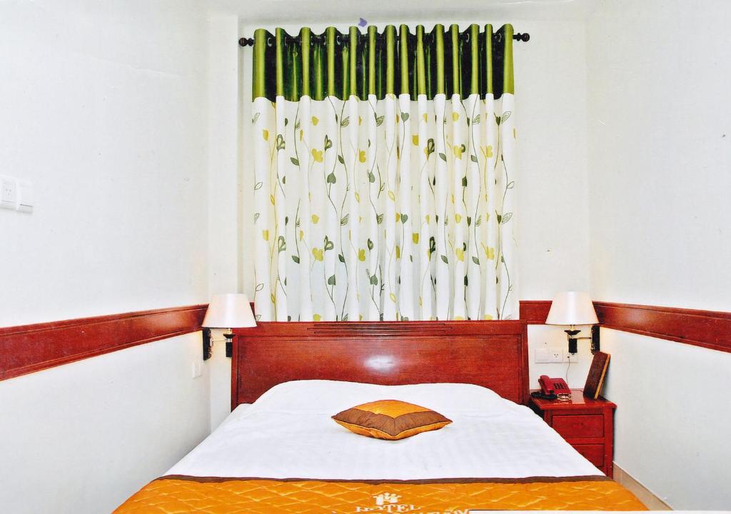 een slaapkamer met een bed en een raam met een gordijn bij Hoang Thanh Thuy Hotel 1 in Ho Chi Minh-stad