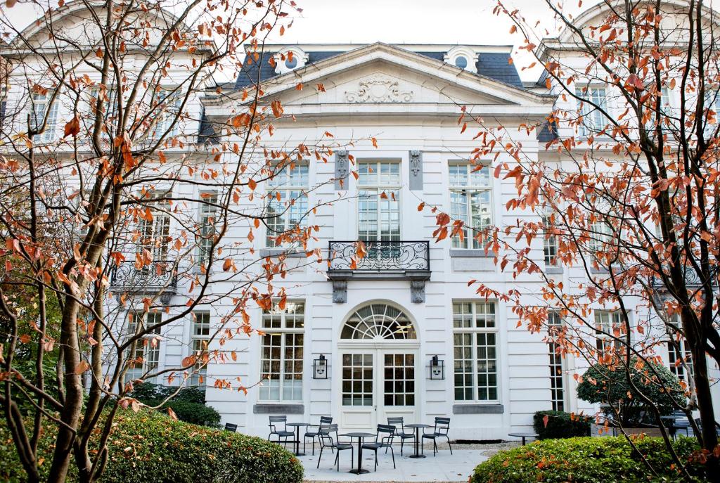 una casa blanca con mesas y sillas frente a ella en Pillows Grand Boutique Hotel Reylof Ghent, en Gante