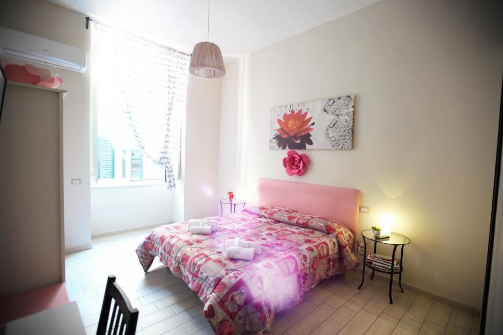 ナポリにあるDomus Armenioのベッドルーム1室(ピンクのベッドカバー付)