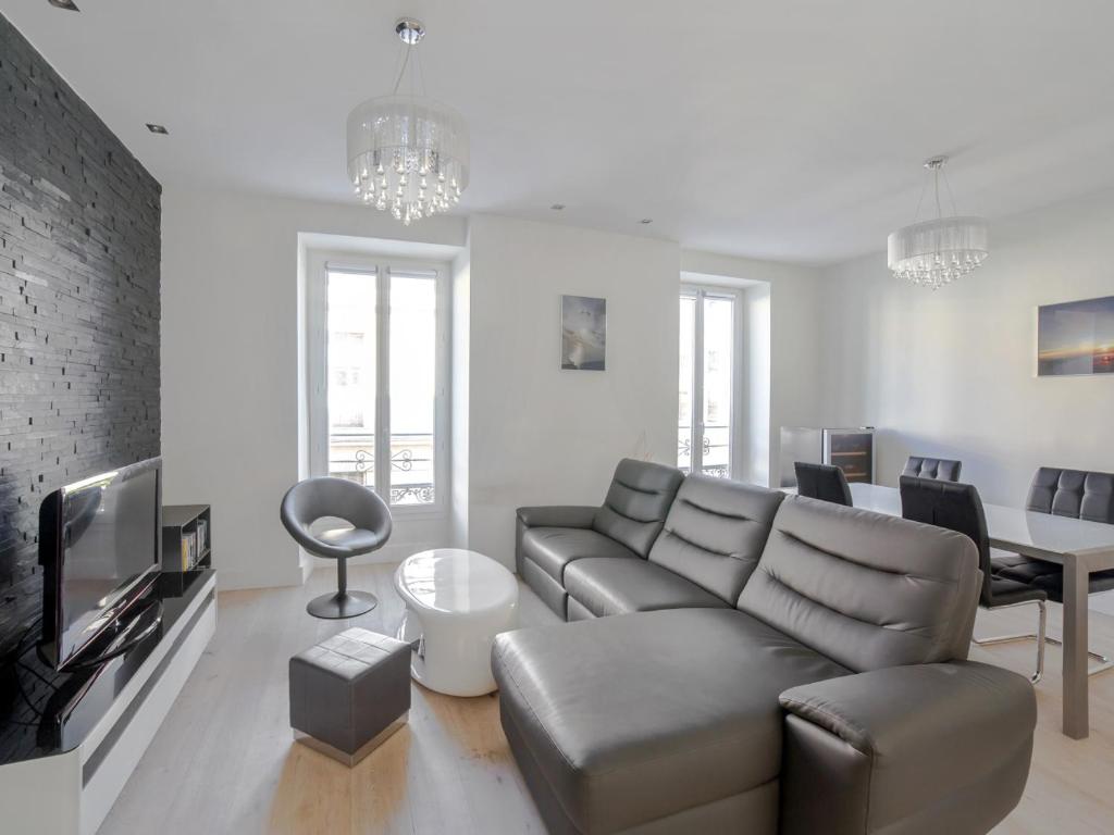 - un salon avec un canapé et une table dans l&#39;établissement Welkeys - Delille Apartment, à Nice