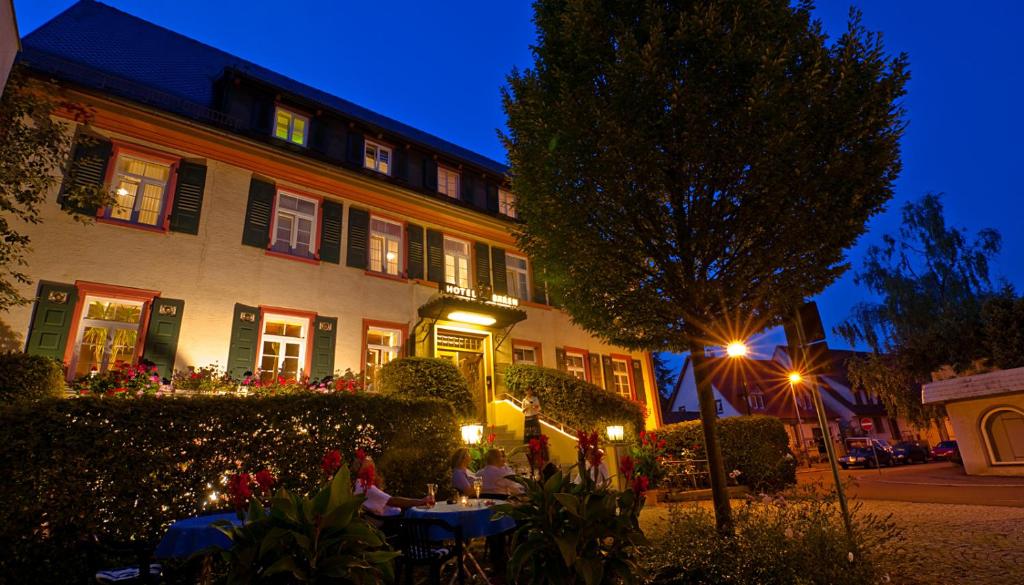 Hotel Bären Trossingen في تروسينغن: مجموعة من الناس يجلسون على الطاولات أمام المبنى