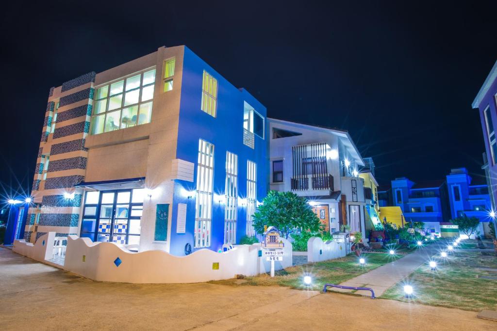 a blue building with lights in front of it at night at Indigo Homestay in Magong