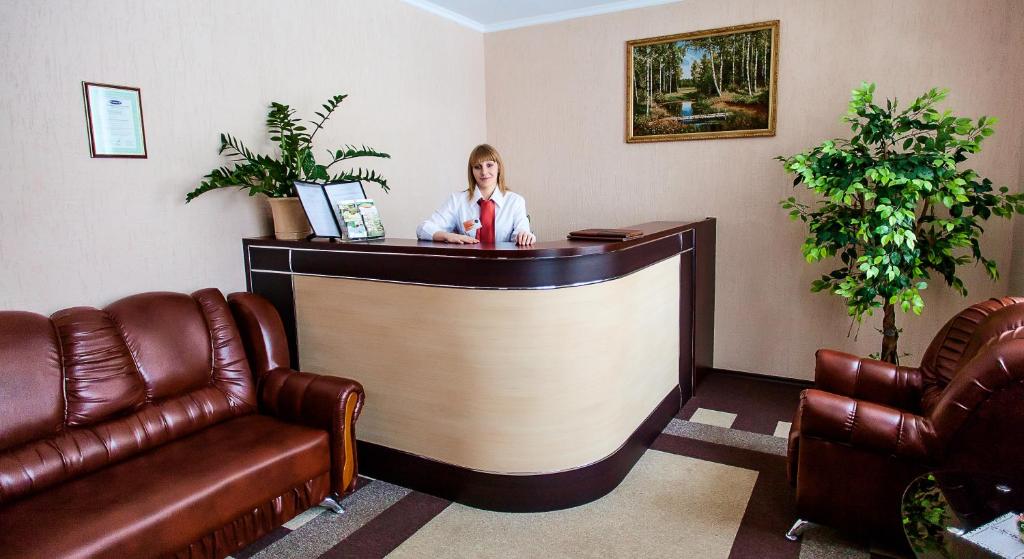Eine Frau, die in einem Wartezimmer an einer Bar sitzt. in der Unterkunft Koltso Hotel in Klintsy