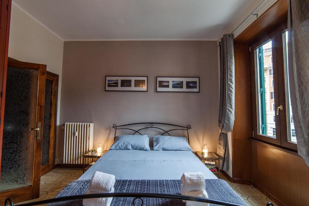 sypialnia z łóżkiem z niebieską pościelą i dwoma oknami w obiekcie Piazza Bologna w Rzymie