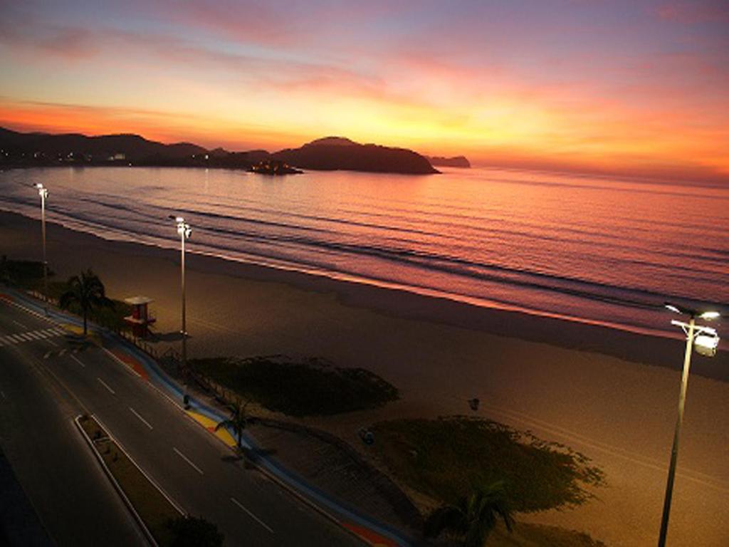 vista para uma praia ao pôr-do-sol com o oceano em Praia do Forte - Condomínio Forte da Praia em Cabo Frio