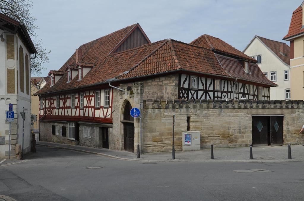 ein altes Steingebäude mit braunem Dach in der Unterkunft Hotel Hahnmühle 1323 in Coburg