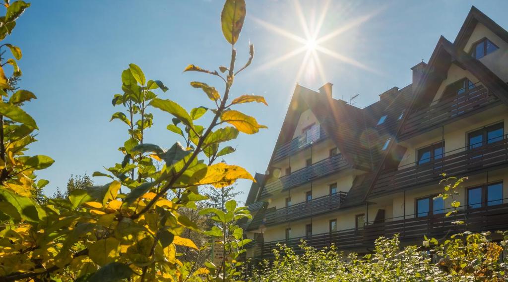budynek ze słońcem w tle w obiekcie Apartamenty Tetmajera APARTZAKOP w Zakopanem