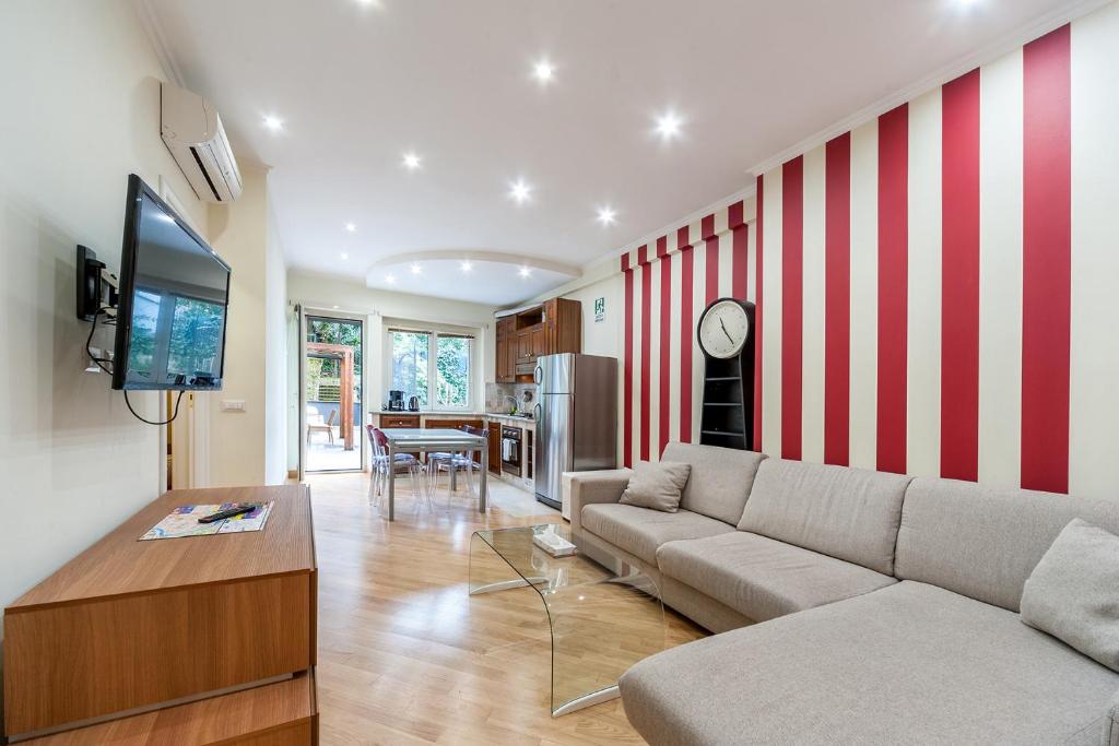 a living room with a red and white striped wall at Nostalgia Romana in Rome