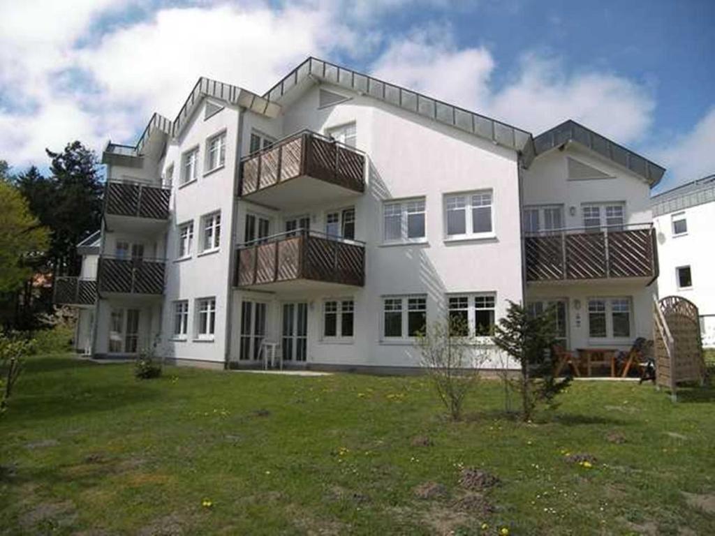 a large white building with balconies on a yard at Seepark Bansin App 101 in Bansin