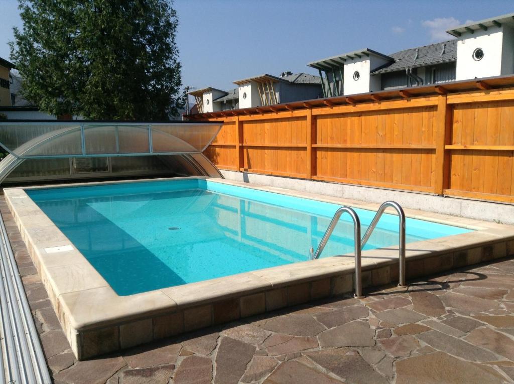 een zwembad met een houten hek en een zonneklep bij Leonsteinerhof in Leonstein