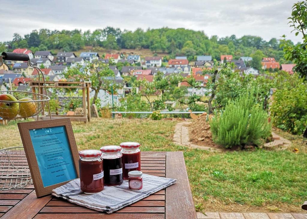 Momlingen的住宿－Ferienwohnung Im Paradies，一张桌子,上面有三罐果酱和一台笔记本电脑