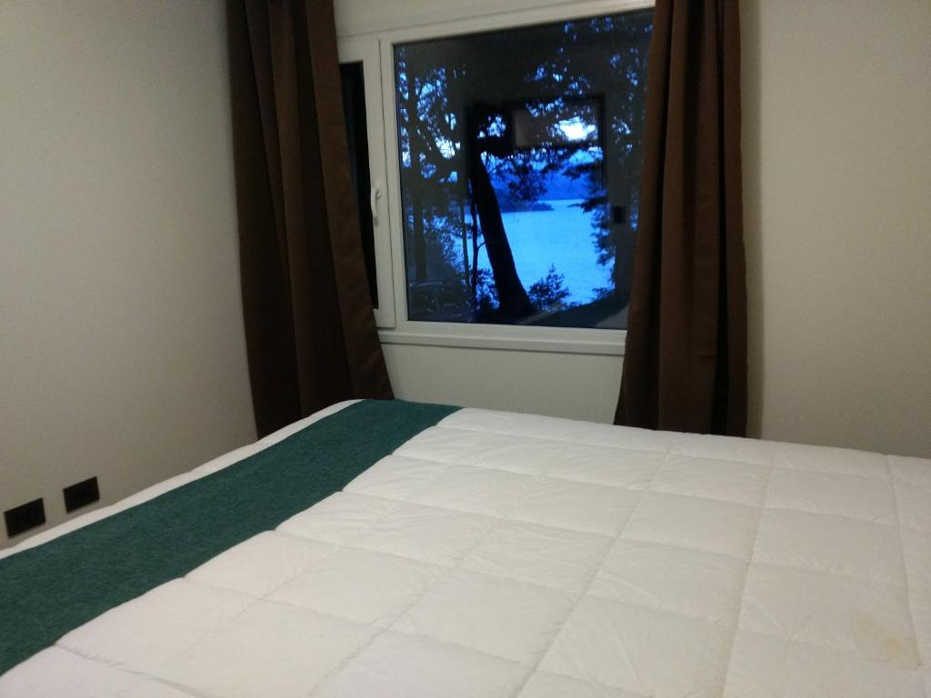 1 dormitorio con cama y ventana en Bustillo Chico en San Carlos de Bariloche