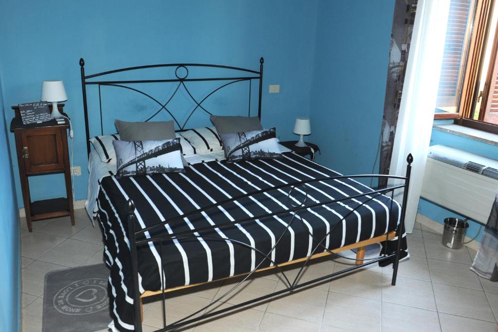 Dormitorio azul con cama blanca y negra en A CASA DI ANNA, en Cerveteri