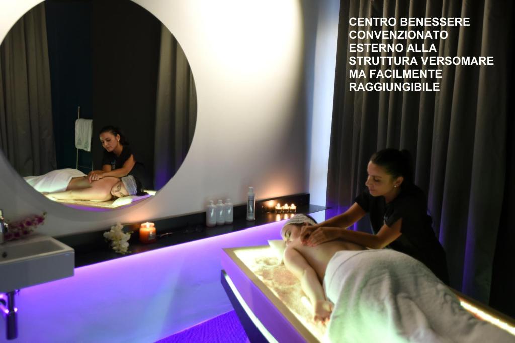 a man getting a massage in a room with two mirrors at Versomare in Polignano a Mare