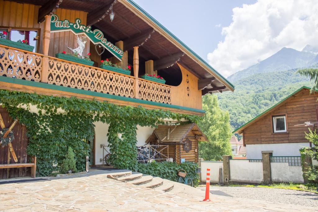 - un bâtiment avec un balcon sur le côté dans l'établissement Rai-Ski-Domik, à Krasnaïa Poliana