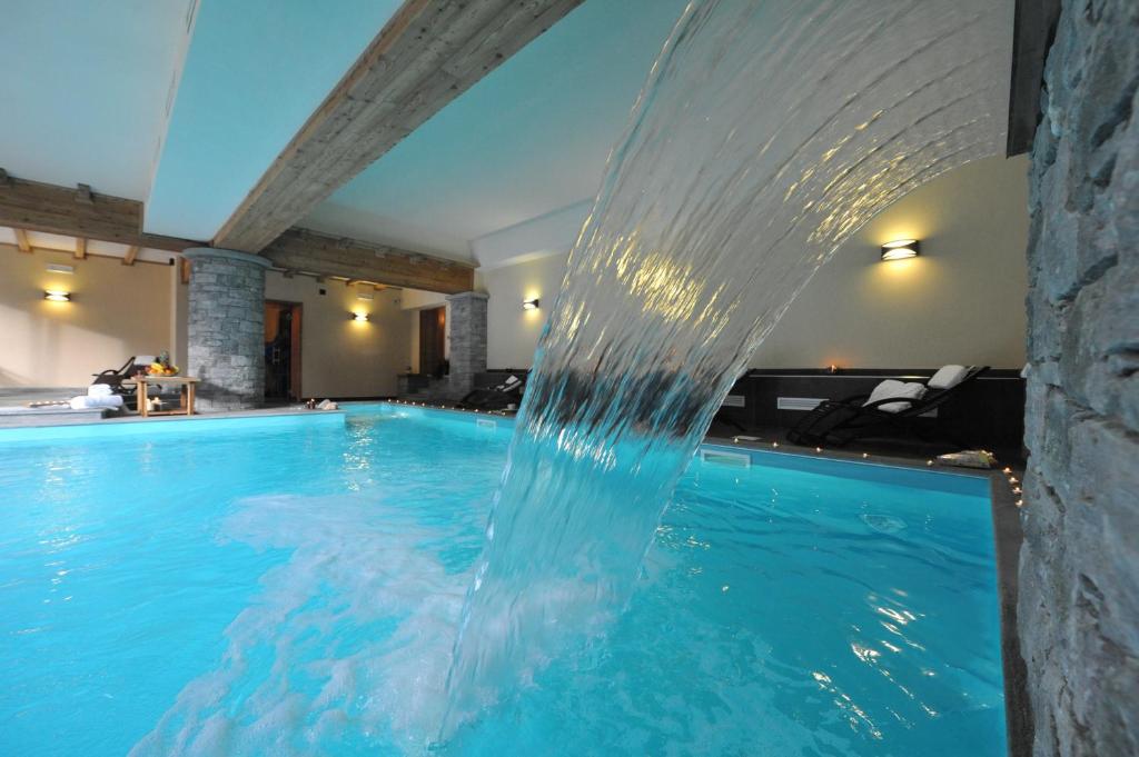 a pool with a water fountain in a hotel at La Rocca Sport & Benessere in Châtillon
