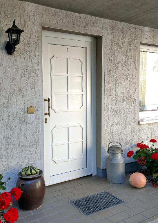 a white front door of a house with flowers at Landhotel Lützen-Stadt in Lützen