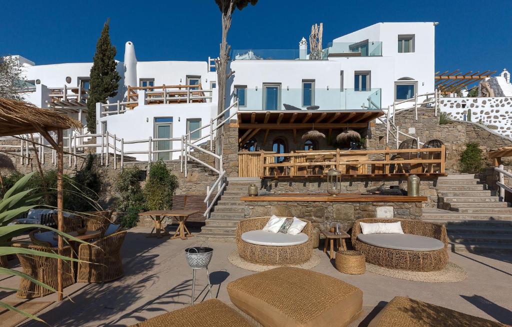 a patio with tables and chairs in front of a building at Legacy Suites in Mýkonos City