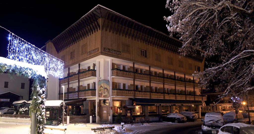 a large building with christmas lights in front of it at Hôtel Les Glaciers in Samoëns