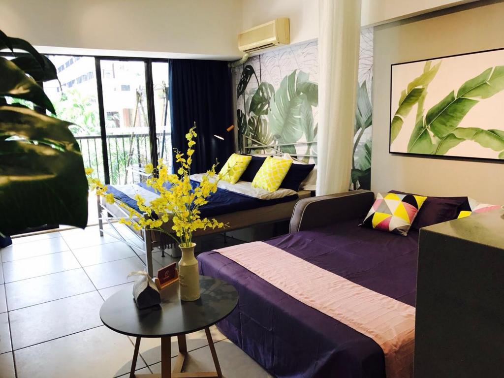 Sanya Sanya Bay·Sanya Bay Tourist Area· Locals Apartment 00164300 في سانيا: غرفة نوم بسرير وطاولة عليها ورد