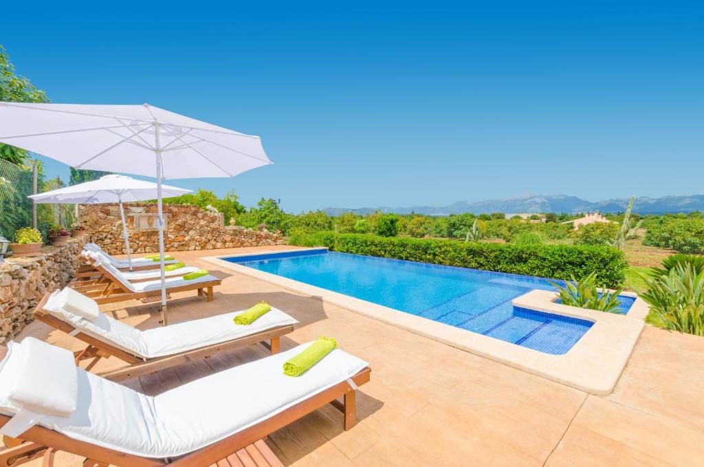 a villa with a swimming pool and patio furniture at Es Moyà Des Pins in Muro