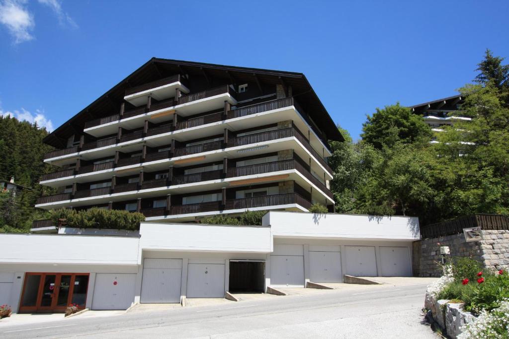 an apartment building with two garages in front of it at Choucas A16 in Crans-Montana