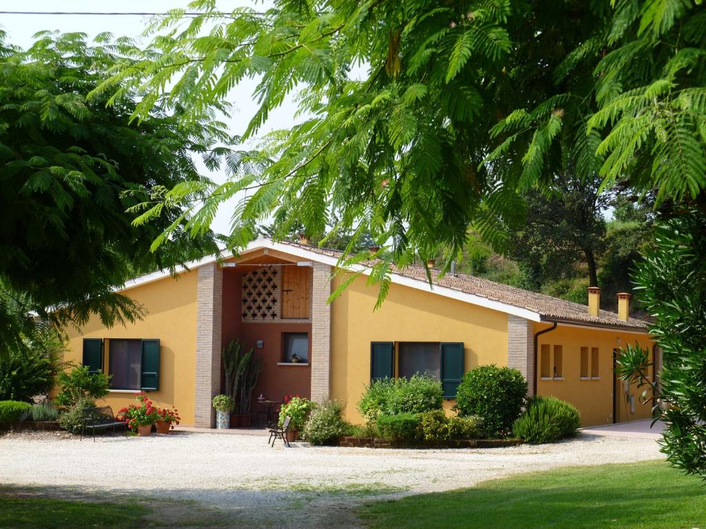 a yellow house with trees in front of it at Agriturismo Dondino in Cavriana