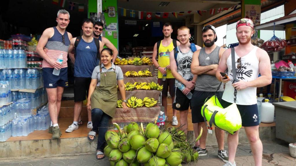 un gruppo di uomini che si trovano di fronte a un negozio di banane di Baansrisuthum a Don Sak