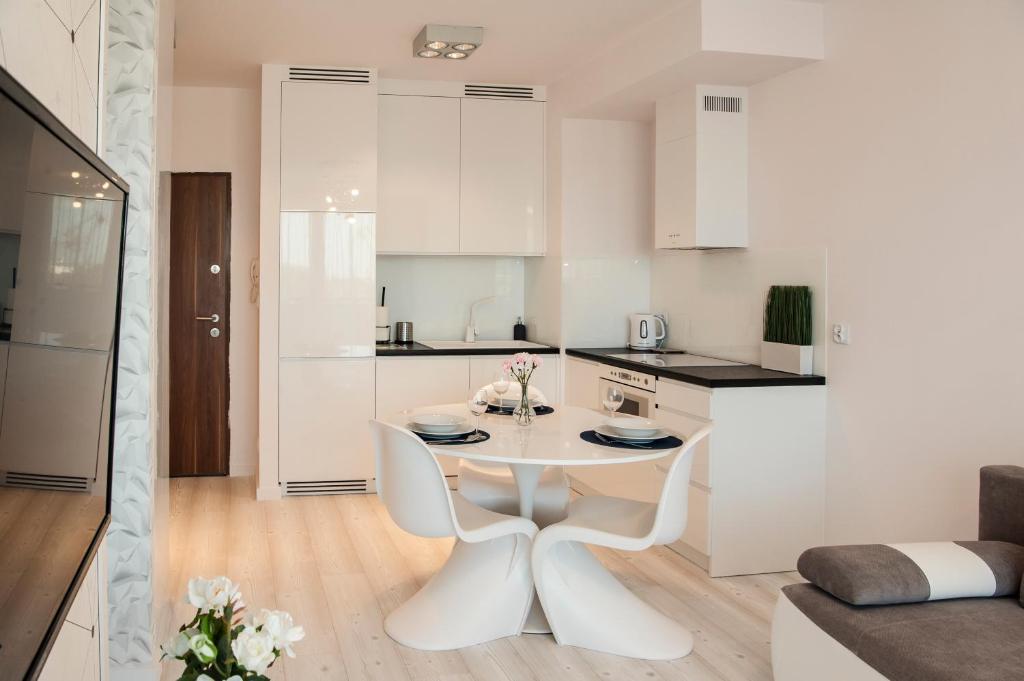 eine weiße Küche mit einem weißen Tisch im Zimmer in der Unterkunft Unique 3city Apartments - Ufo Apartment in Danzig