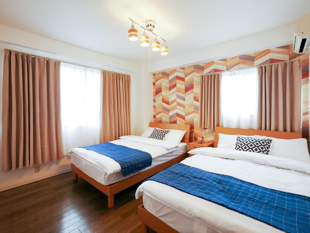pokój hotelowy z 2 łóżkami i oknami w obiekcie Sakura Coco Residence w Osace