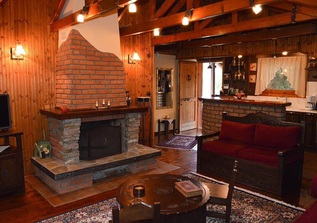 a living room with a fireplace and a red couch at "The plane trees" in Polykárpion