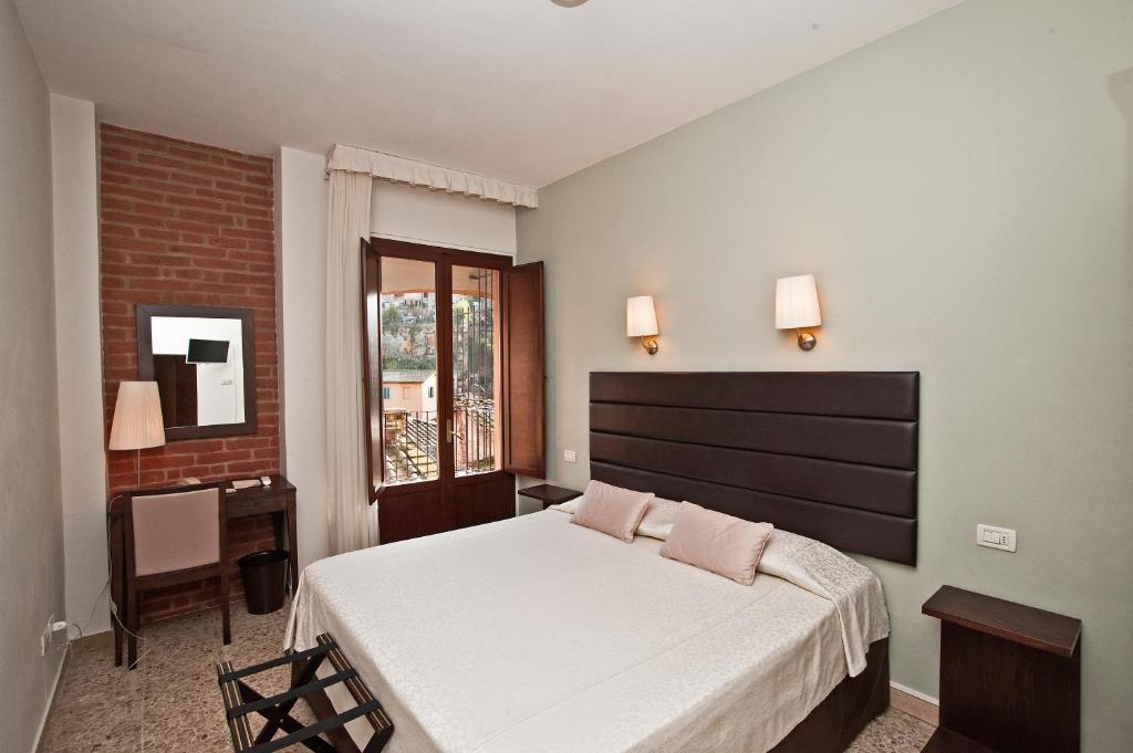 Postel nebo postele na pokoji v ubytování Hotel Alma Domus