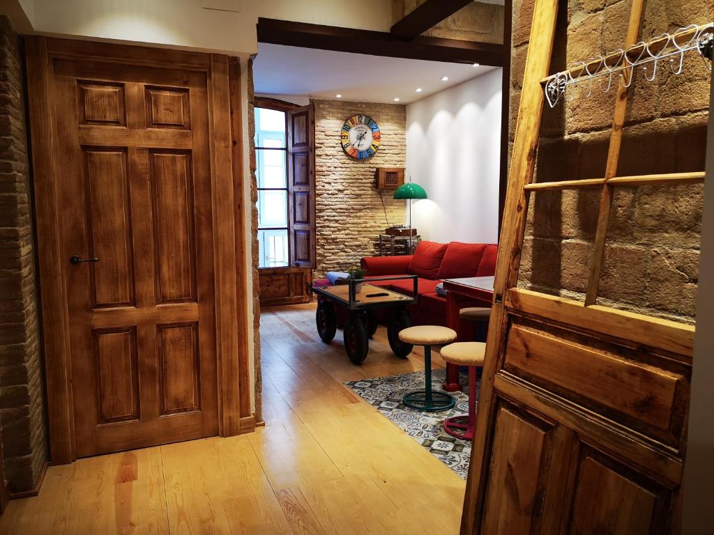 a living room with a door and a red couch at El Capricho de Sagasta in Logroño