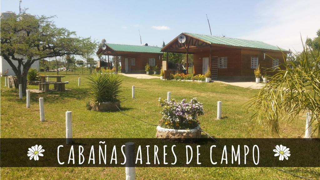 una señal frente a una casa con un edificio en Cabañas Aires de Campos en Colón