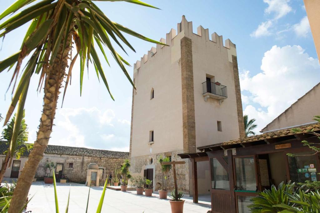un bâtiment avec un palmier devant dans l'établissement Agriturismo sanacore di sanacore salvatore, à Rilievo