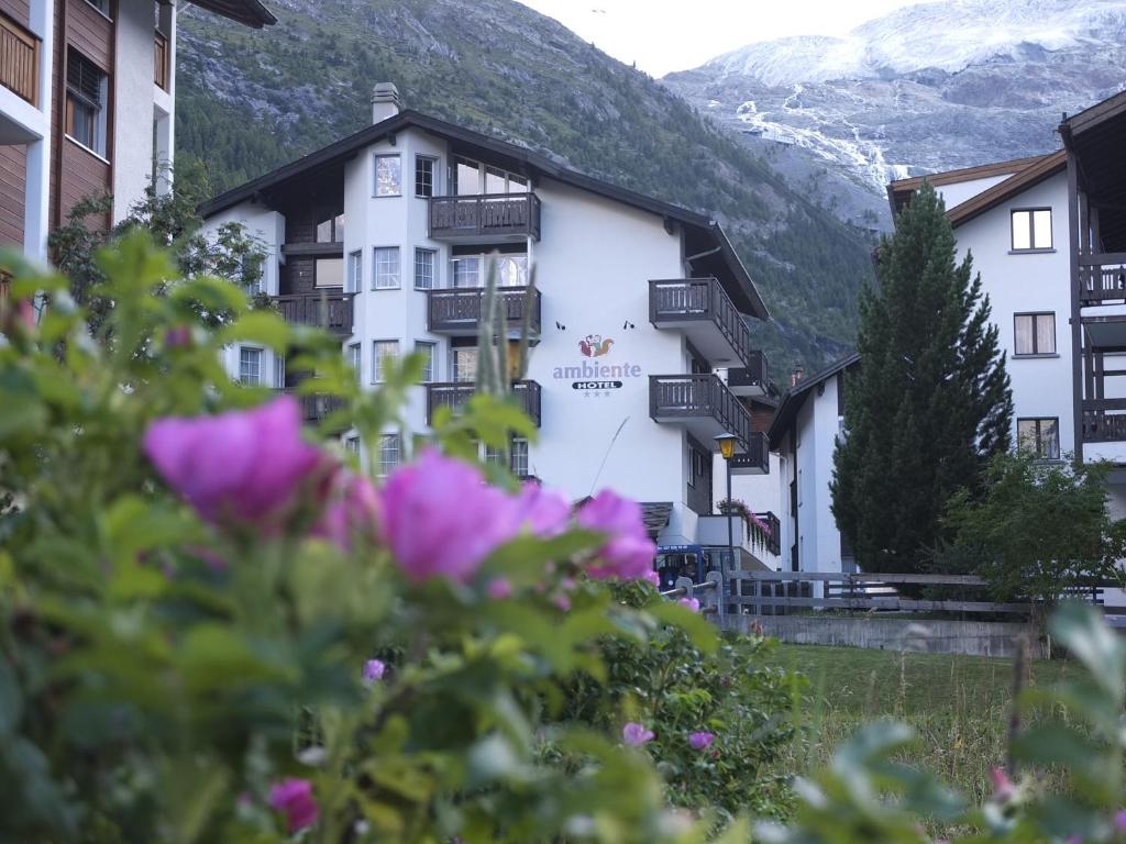 un hotel en las montañas con flores en primer plano en Hotel Ambiente, en Saas-Fee