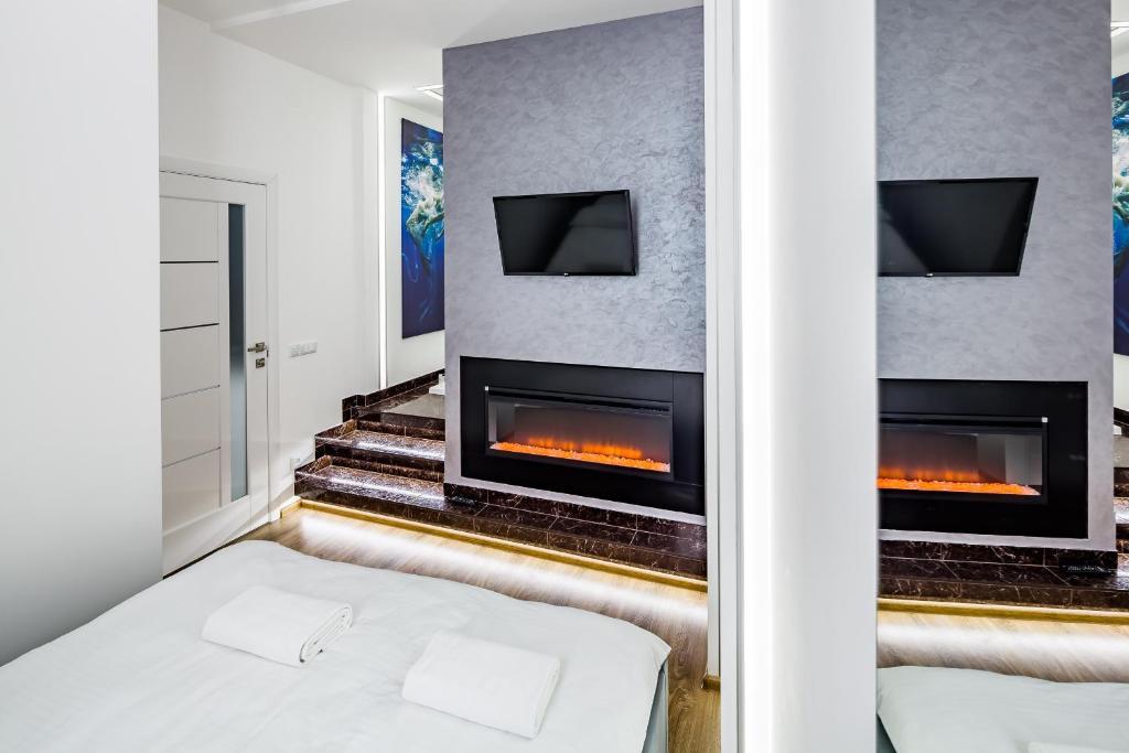 リヴィウにあるRoyal Premier Apartmentのベッドルーム(ベッド1台、暖炉付)
