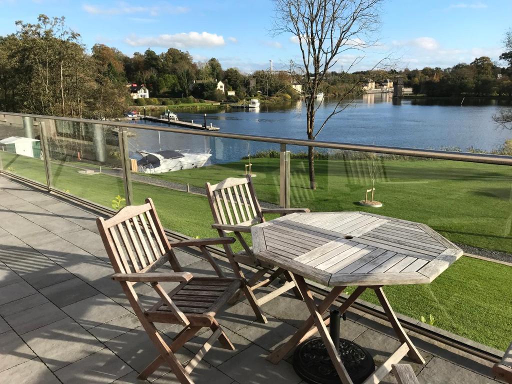 Duas cadeiras e uma mesa num pátio com vista para um lago. em Lakeside Apartment em Enniskillen