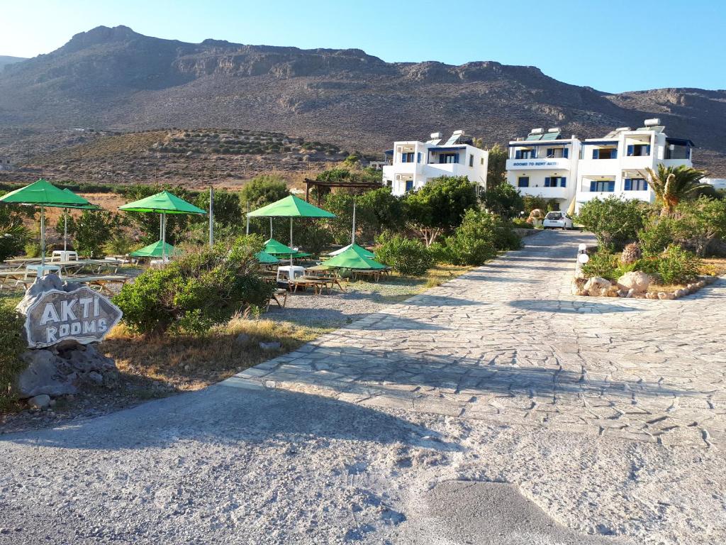 a road with some green umbrellas and some buildings at Akti Rooms in Xerokampos