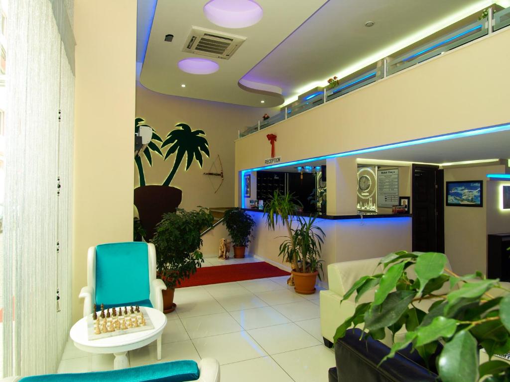 a waiting room with plants and a blue chair at Hotel Timya in Istanbul