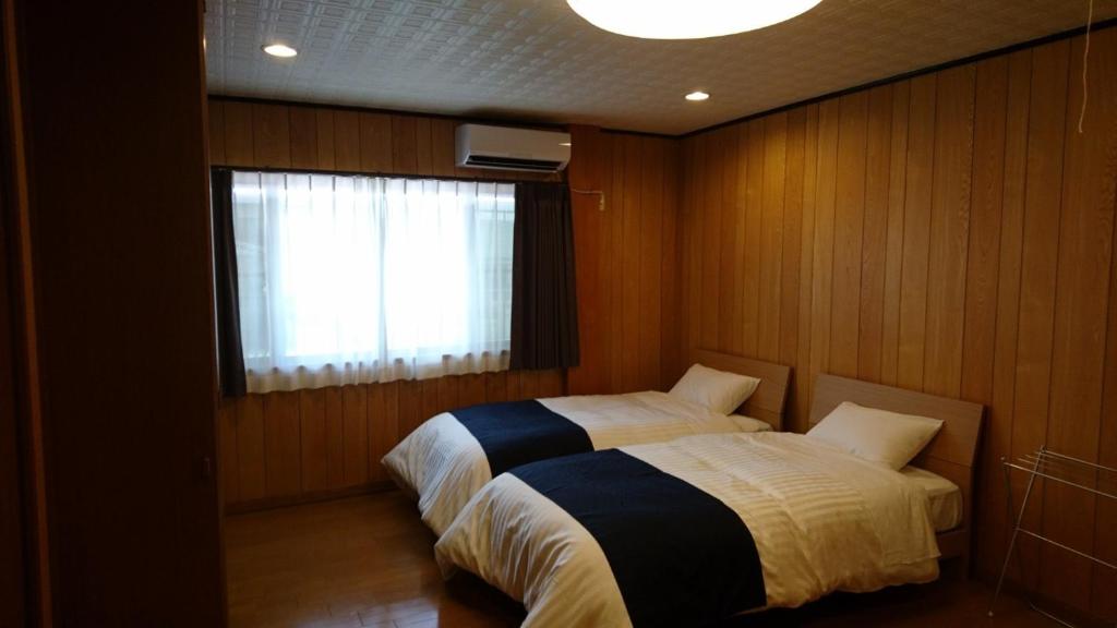 a bedroom with a bed and a window in it at Minpaku Nagashima room2 / Vacation STAY 1036 in Kuwana