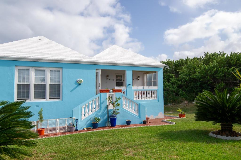 una casa azul con techo blanco en 7 Arches, en Hill View