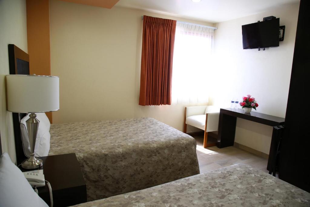 Postel nebo postele na pokoji v ubytování Hotel Plaza Bernal