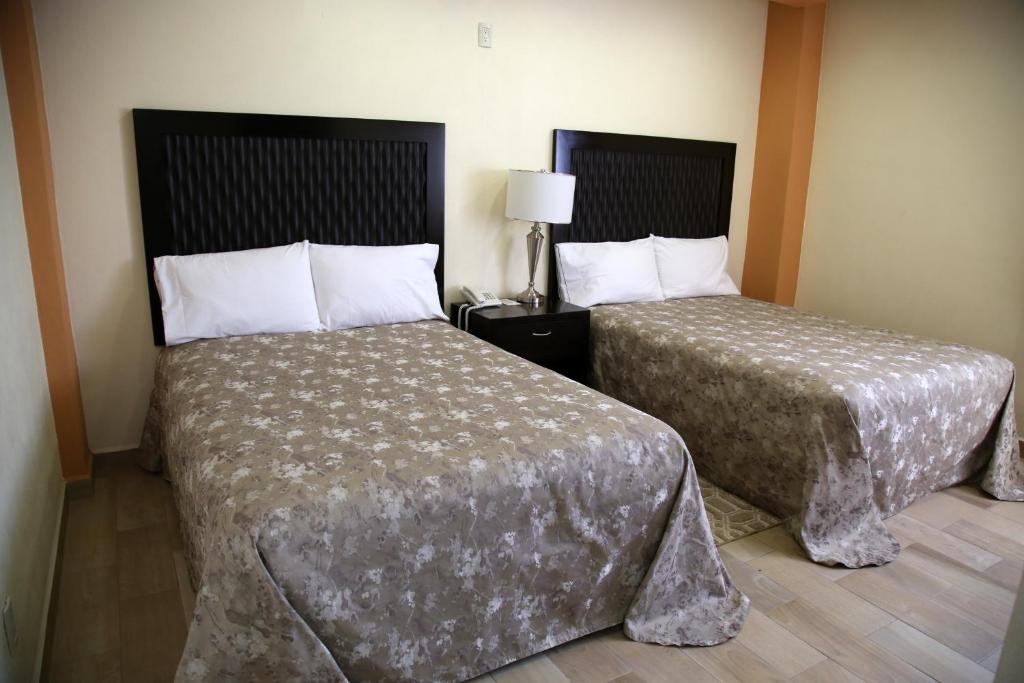 Postel nebo postele na pokoji v ubytování Hotel Plaza Bernal