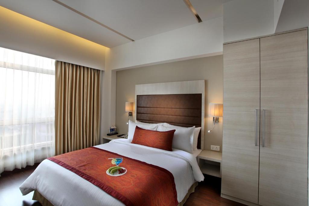 Postel nebo postele na pokoji v ubytování Mahagun Sarovar Portico Suites