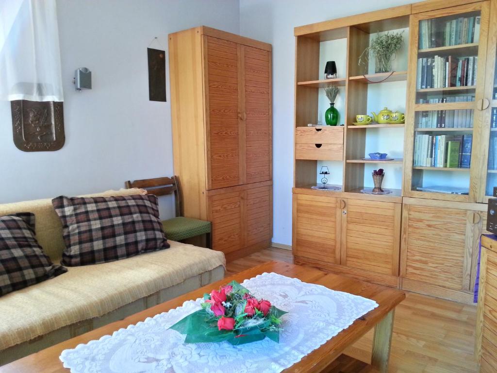 uma sala de estar com um sofá e uma mesa com flores em Akra em Zakopane