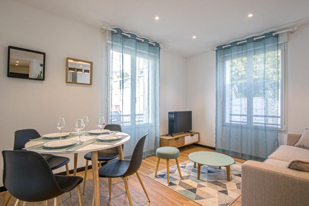 a living room with a table and chairs and a couch at DOUCES NUITS CAENNAISES - Parking Privé inclus, centre ville in Caen