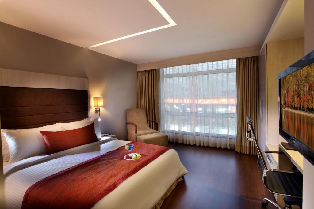 Postel nebo postele na pokoji v ubytování Mahagun Sarovar Portico Suites