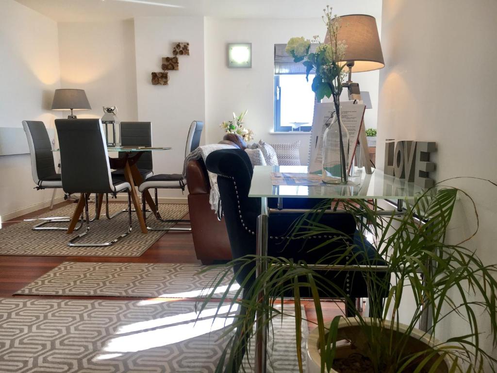 a living room with a table and chairs at Sail view apartment in Swansea