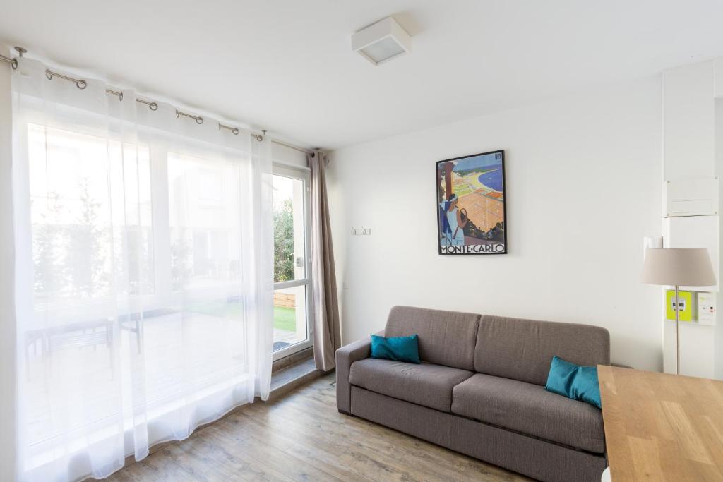 a living room with a couch and a large window at 1Stays Studio - Marlot in Reims